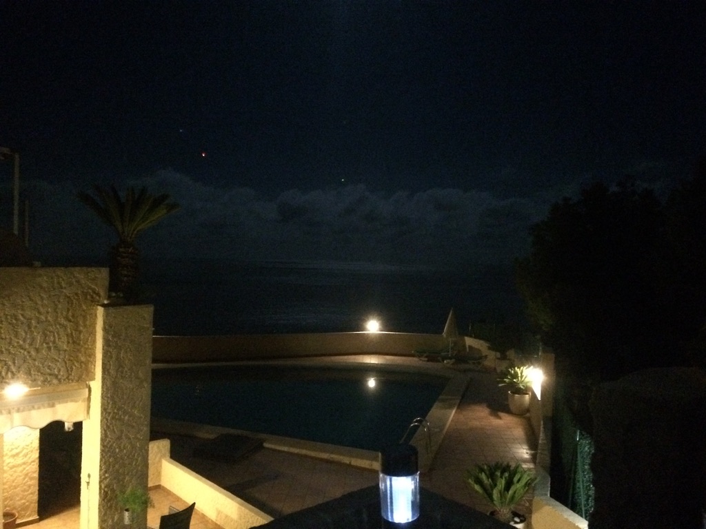Terrace view in Altea with a small red-orange light above the cloud layer
